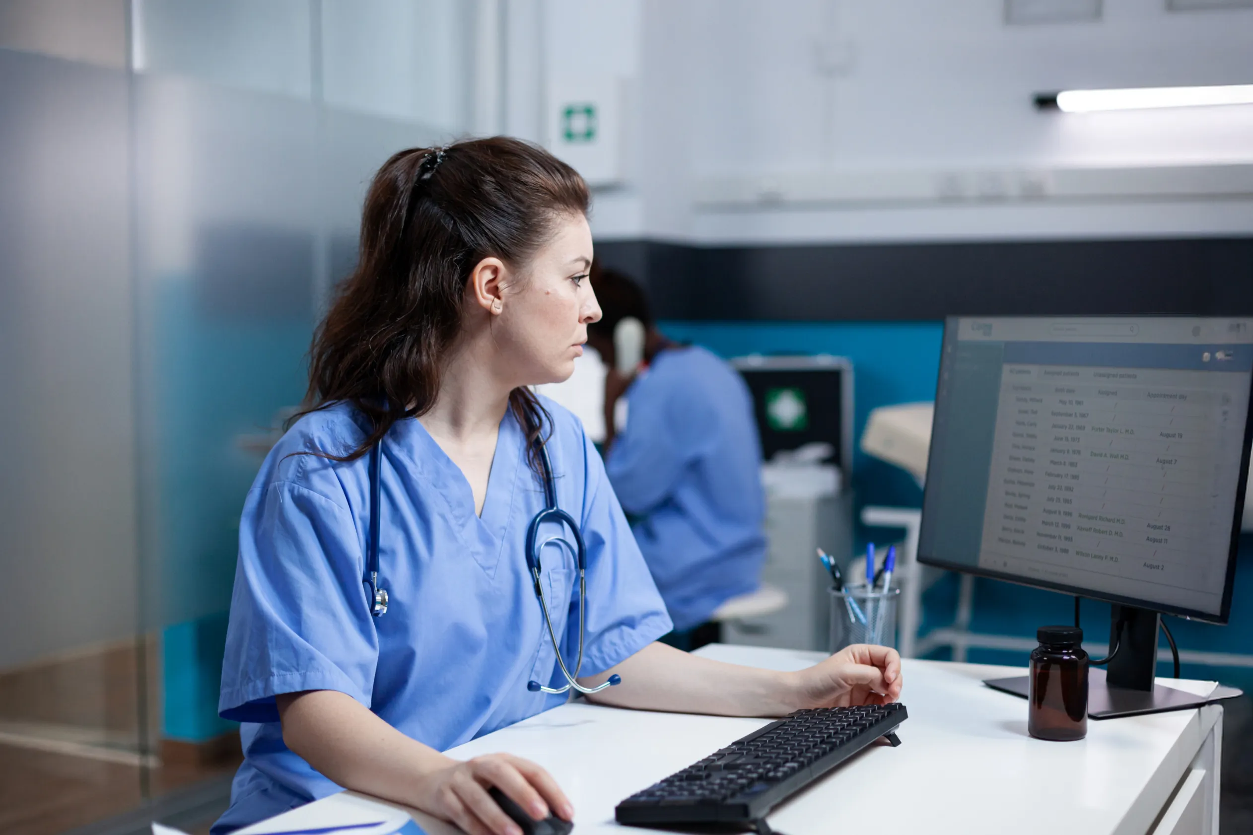 Female medical professional sitting in front of a computer